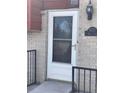 Charming front entrance with a decorative white door, address plaque, and brick facade at 1473 S Monaco S Pkwy, Denver, CO 80224