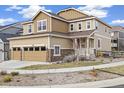 Two-story home featuring a two-car garage, stone accents, and a welcoming front porch with a tidy lawn at 10913 Ledges Rd, Parker, CO 80134