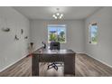 Bright office space features gray walls, wood floors, and a large window providing natural light at 10913 Ledges Rd, Parker, CO 80134