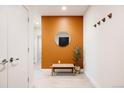 Inviting hallway with a minimalist design, featuring a bench, mirror, and hooks at 2880 Zuni St # 308, Denver, CO 80211