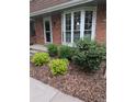 Well-maintained front yard featuring lush green landscaping and a brick facade at 9060 E Cherry Creek South Dr # E, Denver, CO 80231