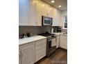 Modern kitchen with stainless steel appliances, white cabinets, and elegant countertops at 9060 E Cherry Creek South Dr # E, Denver, CO 80231