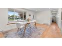 Bright dining room with hardwood floors, a modern table setting, and a large window offering natural light at 1568 S Dudley Ct, Lakewood, CO 80232