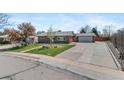 Lovely home with a spacious driveway leading to a detached garage and a well-manicured front yard at 1568 S Dudley Ct, Lakewood, CO 80232