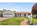 Inviting home with a lush lawn, colorful tree, and a brick pathway at 16308 E Wyoming Dr, Aurora, CO 80017