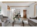 Inviting living room showcases neutral tones, a glass coffee table, and hardwood flooring at 16308 E Wyoming Dr, Aurora, CO 80017