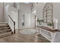 Bright foyer with hardwood floors, a decorative table, and staircase leading to the upper level of the house at 11796 Edenfeld St, Parker, CO 80134