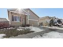 House exterior view with snow on the ground and a driveway at 488 Vista Blvd, Lochbuie, CO 80603