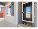 Front entry with black door and welcome mat at 488 Vista Blvd, Lochbuie, CO 80603
