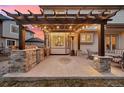 An entertainment-ready outdoor space featuring a pergola with string lights, a built-in grill, and ample seating at 9407 Dolton Way, Highlands Ranch, CO 80126