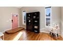 Inviting entryway boasts stylish decor, natural light, hardwood floors, and attractive pink door at 7155 E Exposition Ave, Denver, CO 80224