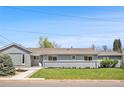 Charming single-story gray home with well-maintained lawn and inviting curb appeal at 7155 E Exposition Ave, Denver, CO 80224