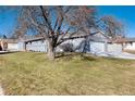 Inviting single-story home showcasing a spacious front yard and mature trees at 7155 E Exposition Ave, Denver, CO 80224