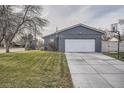 Attached two-car garage with an extra parking spot and basketball hoop, showcasing modern curb appeal at 7155 E Exposition Ave, Denver, CO 80224