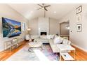 Bright living room with vaulted ceiling, modern fireplace, and a plush white sectional sofa at 7155 E Exposition Ave, Denver, CO 80224