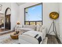 Bright and inviting living room with a sectional, round coffee table, large window, and statement lighting at 7388 S Ireland Cir, Centennial, CO 80016