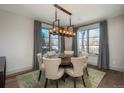 Elegant dining room featuring a modern chandelier, large windows, and a round table with seating for six at 424 Grape St, Denver, CO 80220