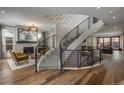 Grand foyer showcasing a curved staircase with modern railing and hardwood floors, inviting and spacious at 424 Grape St, Denver, CO 80220