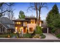 Contemporary home with a stone and wood exterior, featuring a well-maintained lawn and an attached garage at 424 Grape St, Denver, CO 80220