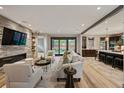 Open-concept living room with stone accent wall, fireplace, neutral furniture, and seamless flow to the kitchen at 424 Grape St, Denver, CO 80220