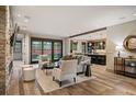 Bright open living room featuring a stone fireplace, modern furniture, and hardwood floors overlooking the kitchen at 424 Grape St, Denver, CO 80220