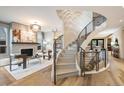 Stunning living room features a modern fireplace, curved staircase, and beautiful hardwood floors at 424 Grape St, Denver, CO 80220