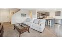 Bright living room featuring a comfortable sofa and seamless transition to the modern kitchen at 9316 Harrison St, Thornton, CO 80229