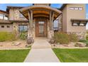 Elegant front door featuring a stone facade, modern design, and professional landscaping at 2466 Spruce Meadows Dr, Broomfield, CO 80023