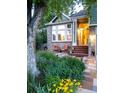 Inviting home featuring a colorful front garden, a quaint seating area, and a charming brick facade at 601 E 131St Ct, Thornton, CO 80241