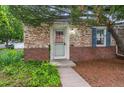 Close-up of the front door with brick accents and tidy landscaping at 1279 Leyden St, Denver, CO 80220