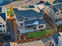 Aerial view of a backyard with a grass area, play set, covered patio, and a wooden fence surrounding the area at 515 Orion Ave, Erie, CO 80516