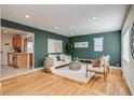 Cozy living space with hardwood floors, green wall, and seamless flow to the kitchen at 1060 Grove St, Denver, CO 80204