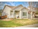 Charming home featuring a covered front porch and well-maintained lawn at 19691 E 59Th Dr, Aurora, CO 80019