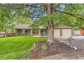 Beautiful home with mature trees, manicured lawn, and a brick exterior at 2473 S Carr Ct, Lakewood, CO 80227