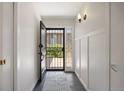 Bright entryway with slate flooring, white walls, decorative molding, and a view through the security door at 2711 S Fenton St, Denver, CO 80227
