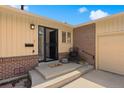 Charming front porch with black security door, 'Hello' mat, and brick accents, leading to the home's entrance at 2711 S Fenton St, Denver, CO 80227