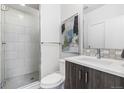 Modern bathroom with a glass shower, white tiles, and stylish vanity at 3207 W 25Th Ave, Denver, CO 80211