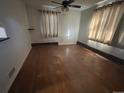 Hardwood floor living room with large windows and a ceiling fan at 701 S Pecos St, Denver, CO 80223