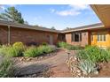 Charming brick home showcases lush flowerbeds and a stone walkway at 92 S Devinney St, Golden, CO 80401