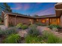 Charming brick home showcases lush flowerbeds and a stone walkway at 92 S Devinney St, Golden, CO 80401