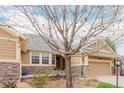 Home featuring stone accents, a well-manicured lawn, and a charming front porch at 8525 E 149Th Dr, Thornton, CO 80602