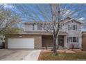 Charming two-story home featuring brick accents, blue shutters, and a well-maintained front yard with mature trees at 613 Rio Rancho Way, Brighton, CO 80601