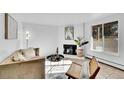 Cozy living room featuring neutral tones, a brick fireplace, and abundant natural light at 2700 S Holly St # 107, Denver, CO 80222