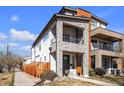 Striking modern home featuring stone accents and a private balcony on a sunny day at 2305 Quitman St, Denver, CO 80212