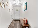 Bright entryway with modern light fixture and bench seating. Features updated floors and white walls at 2985 W 46Th Ave, Denver, CO 80211