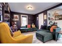 Cozy living room with dark walls, light floors, comfy sectional, and accent furniture pieces at 2852 W Ellsworth Ave, Denver, CO 80219