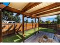 Cozy backyard retreat with a wooden pergola, fenced yard, and lush green grass at 3903 W Nevada Pl, Denver, CO 80219