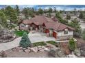 Aerial view of a stunning home featuring a stone and stucco exterior and a large driveway at 2094 Lost Canyon Ranch Ct, Castle Rock, CO 80104