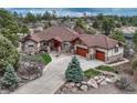 Beautiful stone-accented home with a three-car garage and a winding driveway leading to the entrance at 2094 Lost Canyon Ranch Ct, Castle Rock, CO 80104