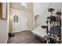Bright foyer with high ceilings, hardwood floors, and staircase; includes decorative mirror and cat tree at 11093 Nome St, Commerce City, CO 80640